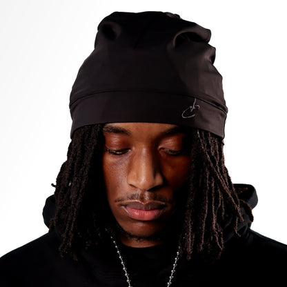 Person wearing a black beanie and hoodie on a white background